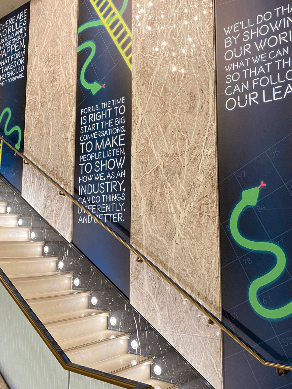 Three wall banners going up the stairs displaying company objectives and goals